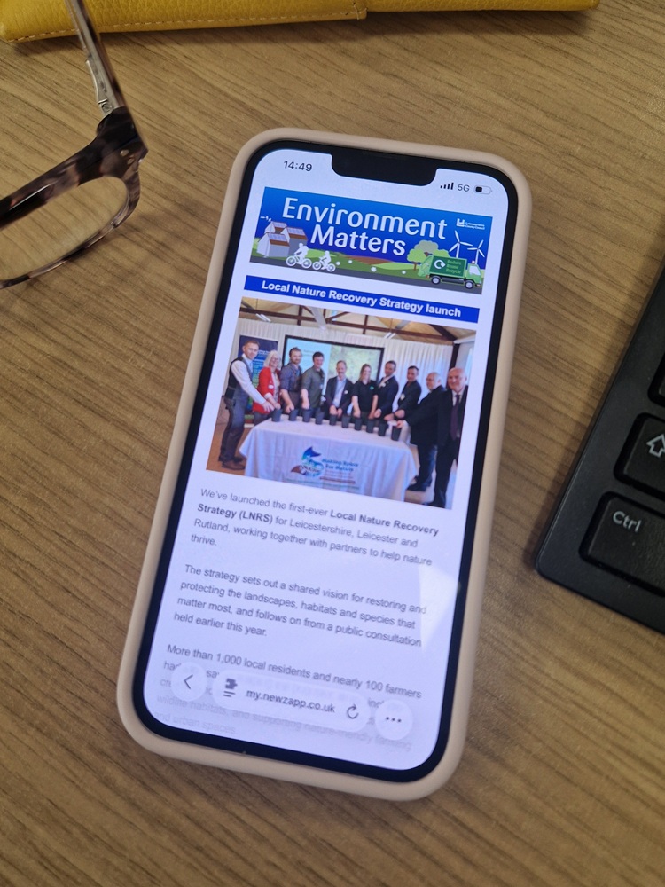 Mobile phone on a desk with the Environment Matters newsletter on screen