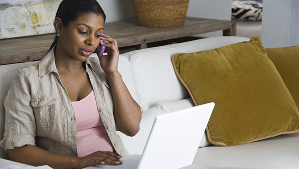 Person on the phone and looking at a laptop Person on the phone and looking at a laptop