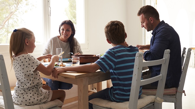 Family eating a meal together around a table