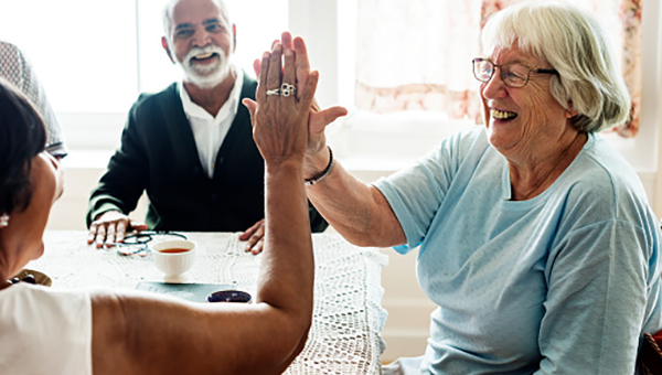 Two women laughing and giving each other a high-five