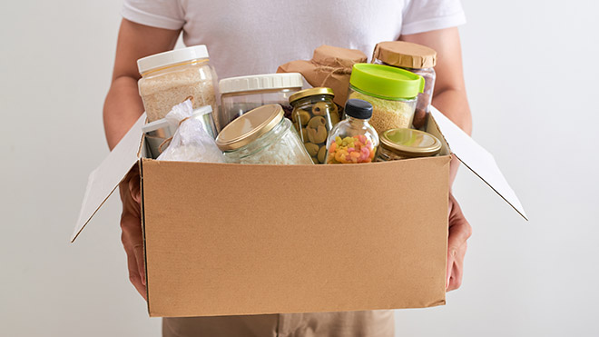Help with the cost of food is available Man holding a box of food