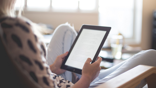 person reading a book on a tablet