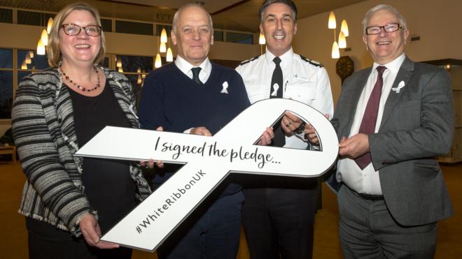 Jane Moore, director of children and families at Leicestershire County Council, Nick Rushton, leader of Leicestershire County Council, Deputy Chief Constable Rob Nixon and Police and Crime Commissioner, Lord Willy Bach sign the White Ribbon Pledge Domestic violence