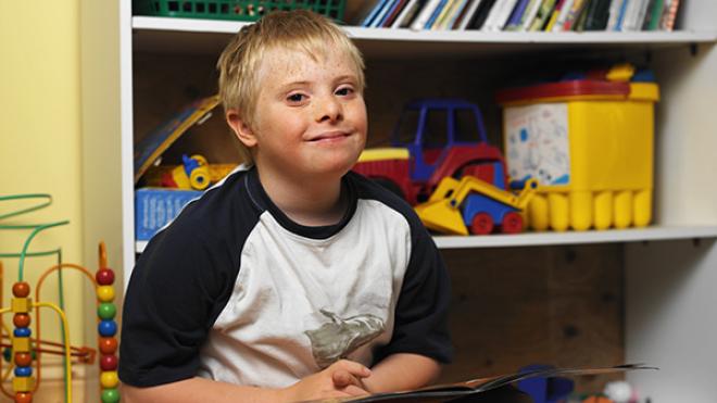 Young boy in front of bookcase at school
