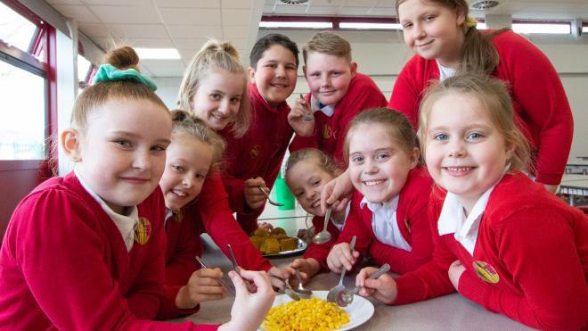 Pupils at Robert Bakewell School, Loughborough tucking into delicious sweetcorn School pupils sat at a table eating sweetcorn