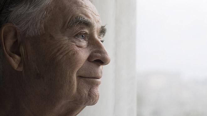 Older person looking out of a window