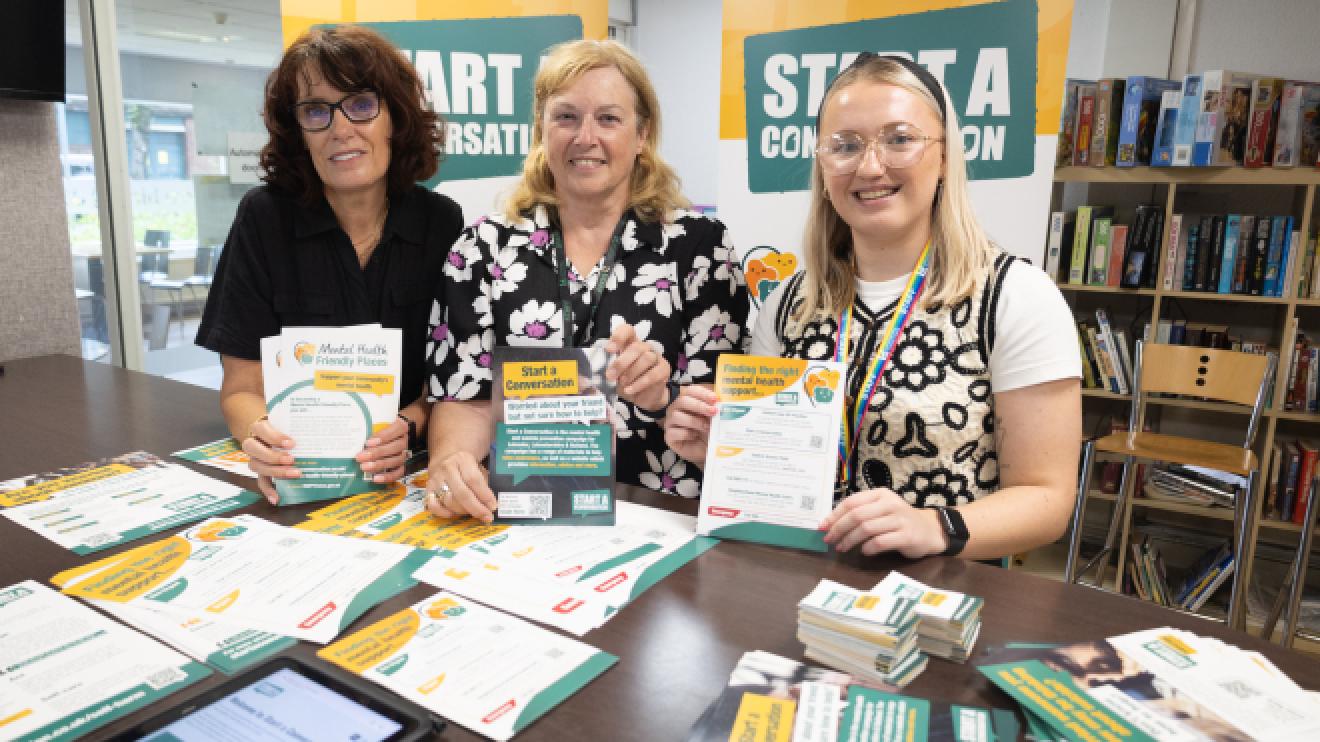 Representatives of John Storer House and Leicestershire County Council launching Mental Health Friendly places, each posing with Start a Conversation leaflet