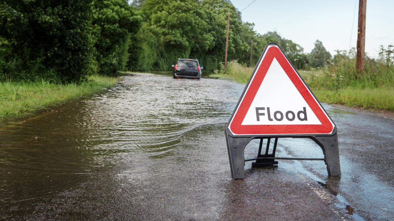 Flooded road with stranded car