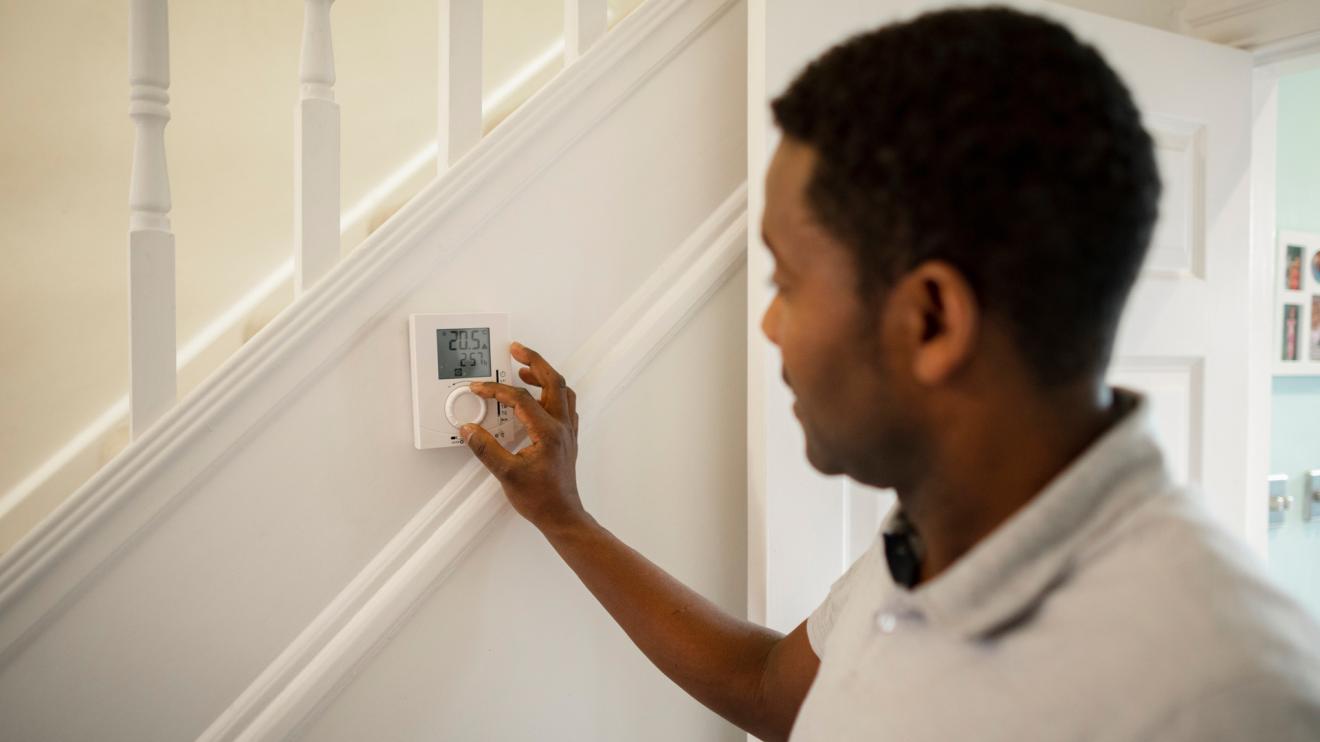 Man turning down thermostat