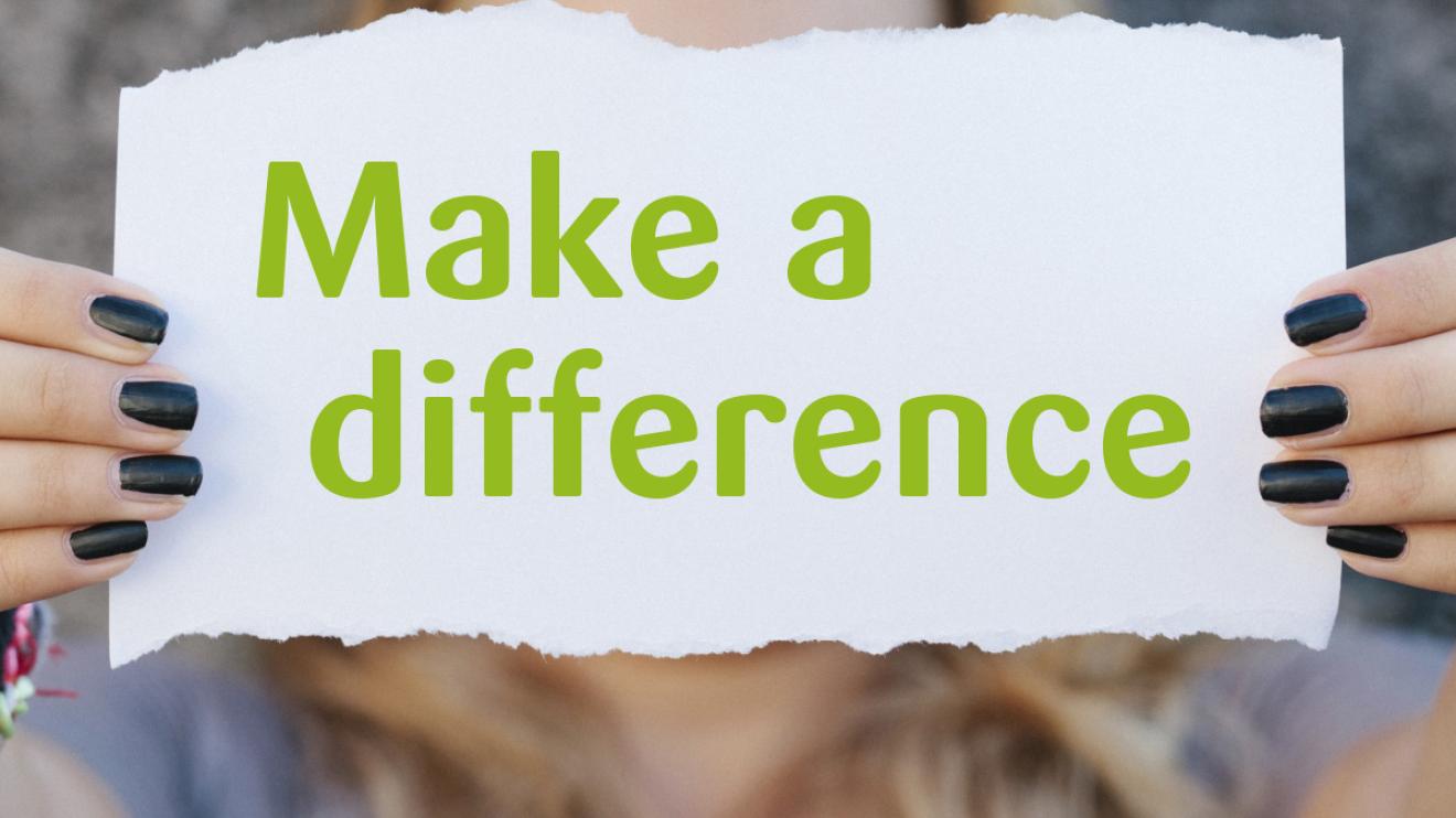 Person holding up a note with the words Make a difference