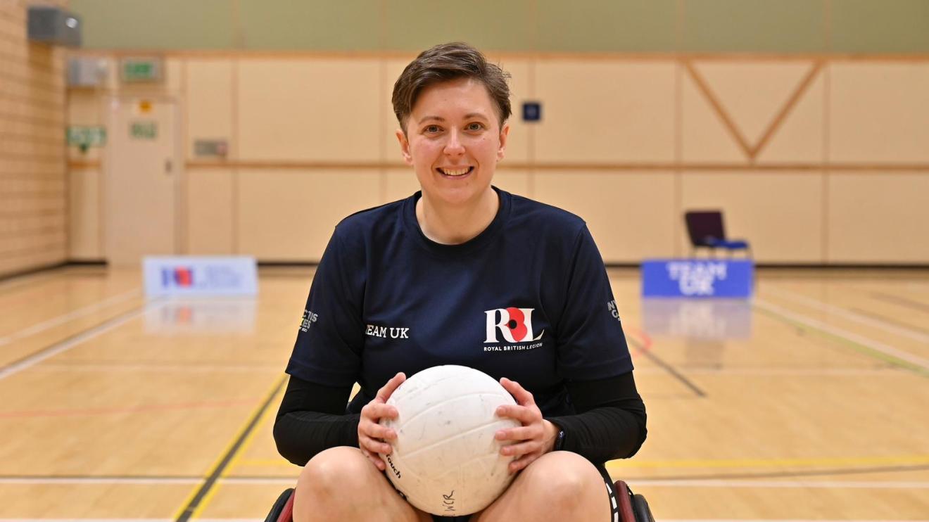 Elisabeth Lee, a wheelchair basketball player, for the Invictus Games Elisabeth Lee sits in a wheelchair holding a ball in a sports court, representing Team UK at the Invictus Games 2023
