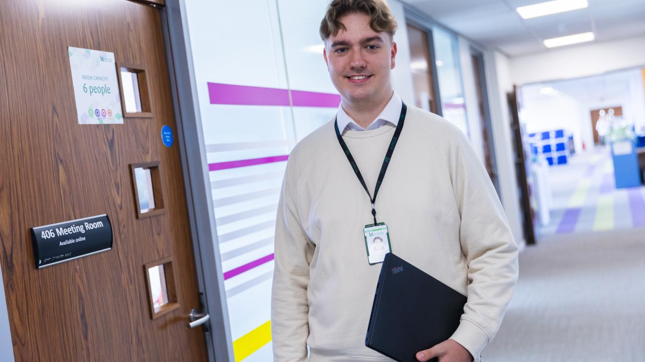 Alexander Farmer holding a laptop in the office
