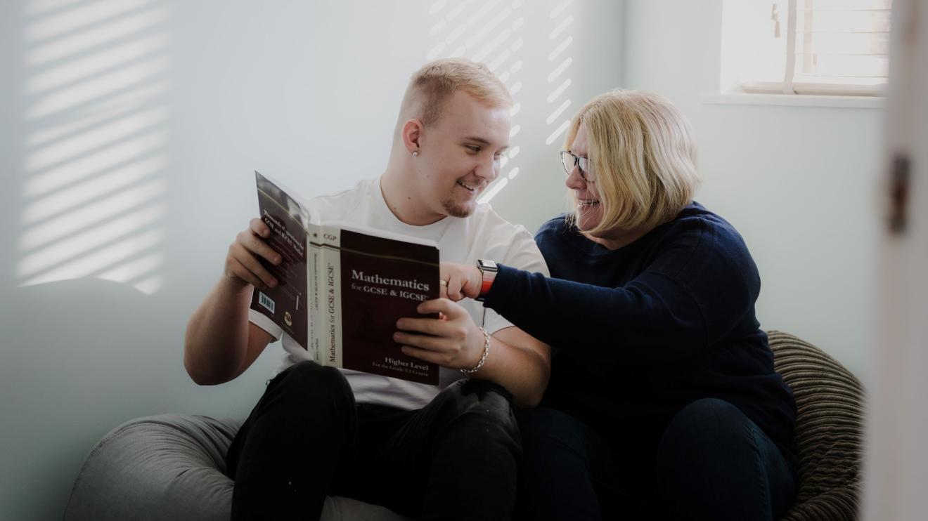 Teenage boy and woman looking at a book