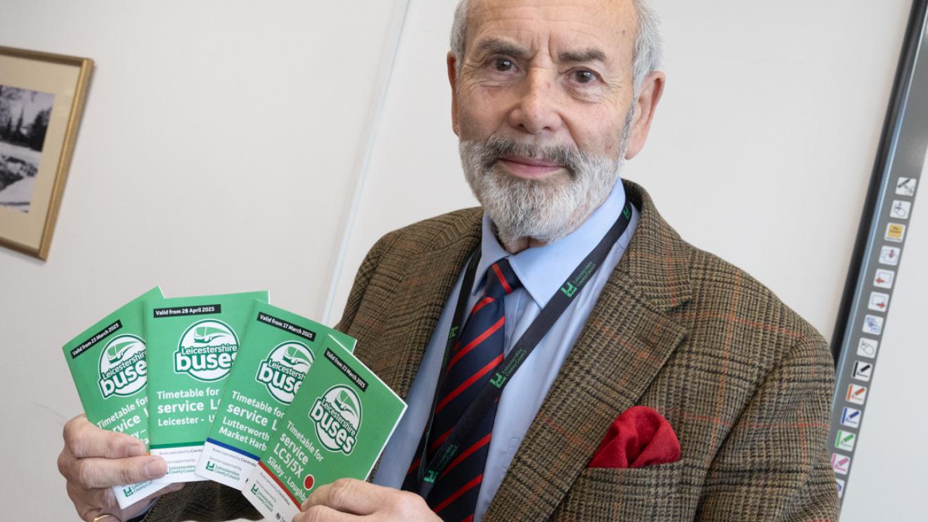 Councillor Dan Harrison with new bus timetables