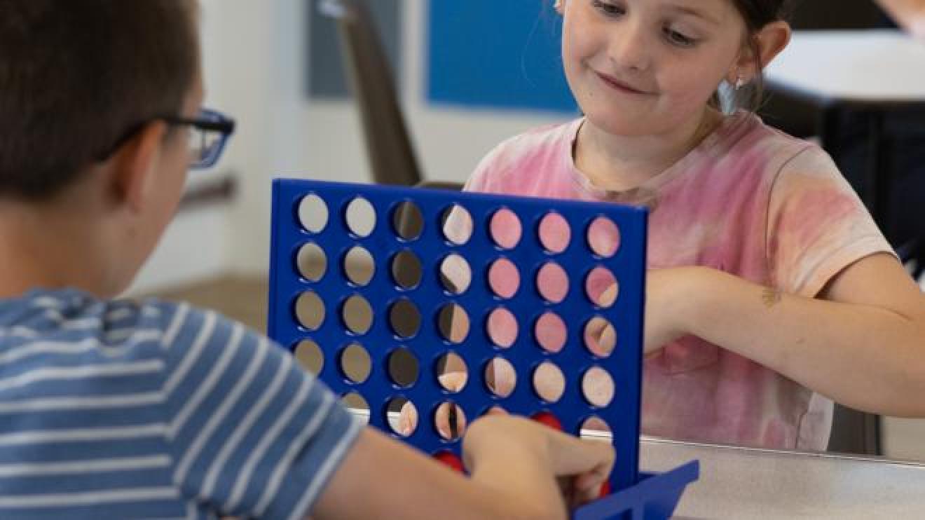 Two children play a board game
