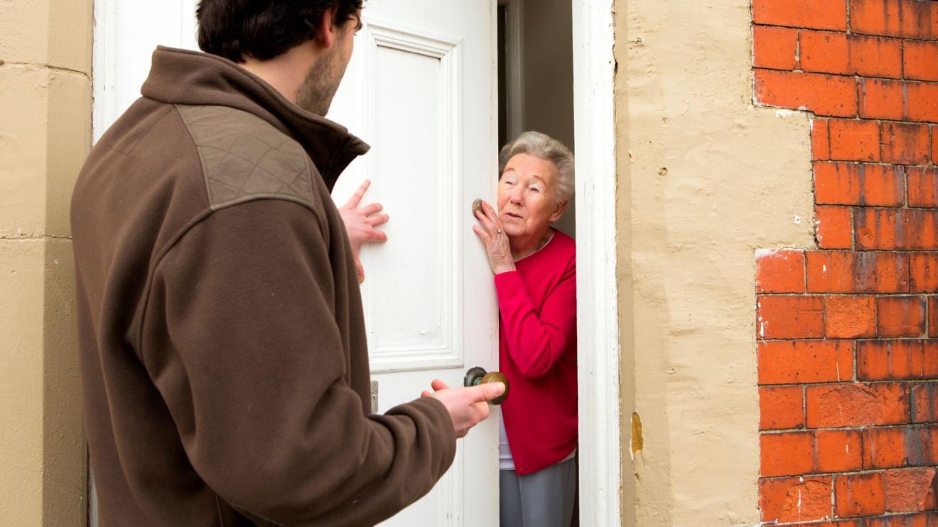Rogue trader talking to woman at front door