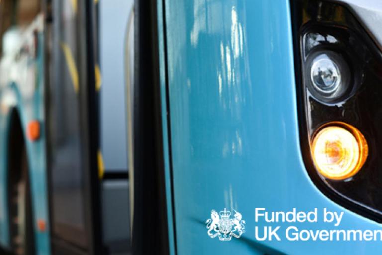 Close up of a bus accompanied by the 'funded by UK government' logo