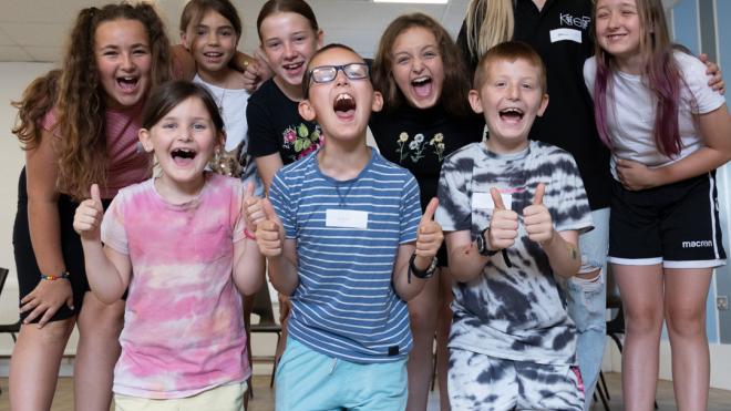 Group of children and staff members smiling