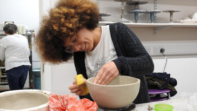 Woman making a pot on a wheel