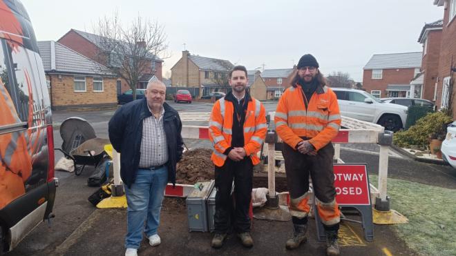 Councillor Ozzy O'Shea standing in front of Cadent gas works on a footpath in Ratby, alongside two representatives of Cadent Gas wearing hi-vis jackets