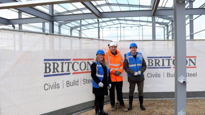 Cllr Lee Breckon with Lucy Littlefair and Lee Noble of Britcon inside the steel structure of Airfield Business Park