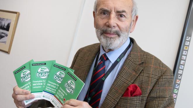 Councillor Dan Harrison with new bus timetables