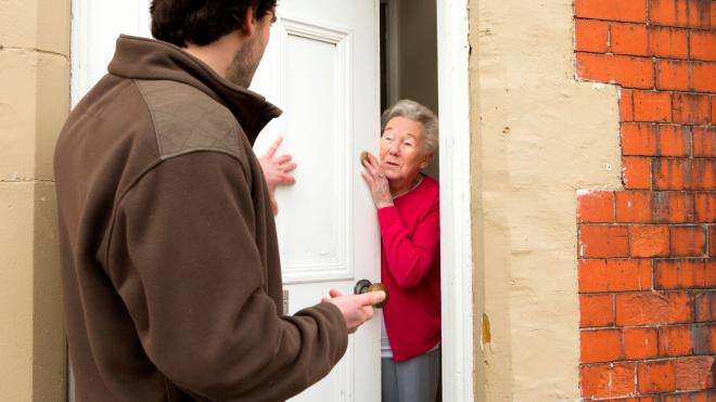 Rogue trader talking to woman at front door