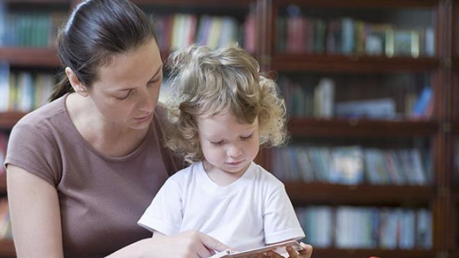 lady reading to a chld in a library