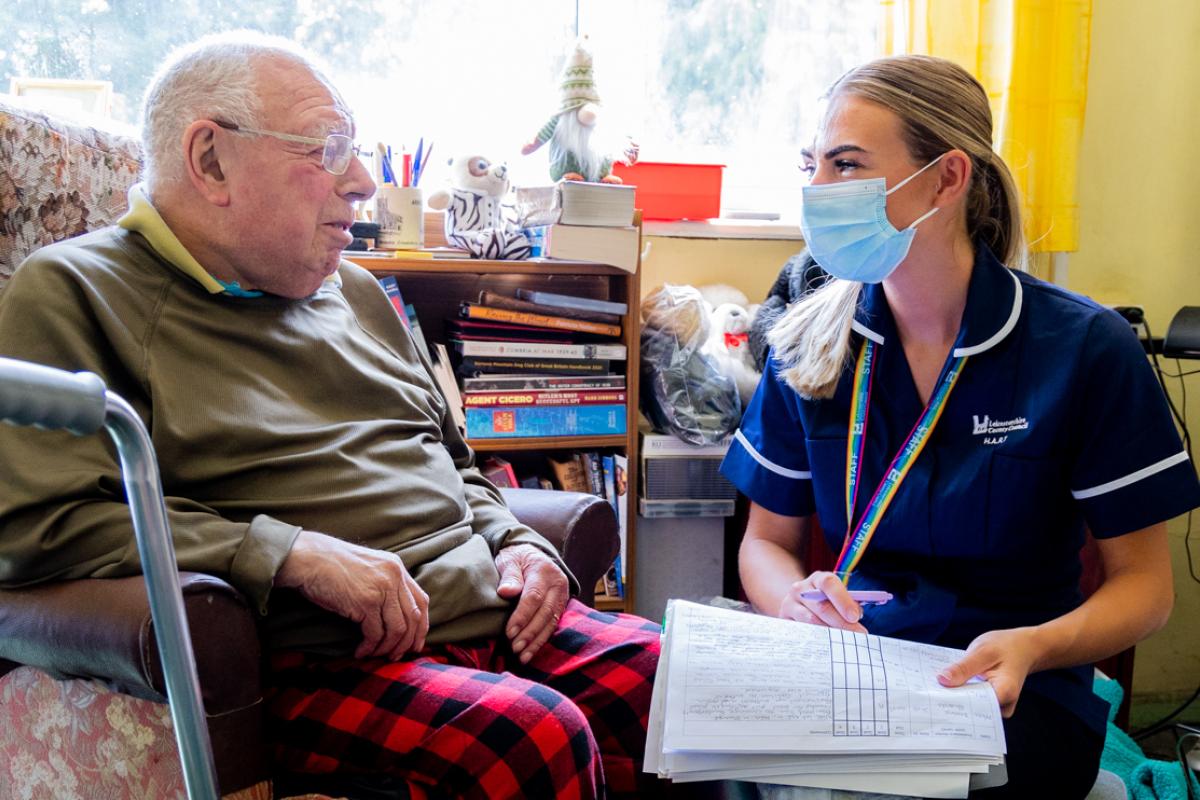 Social worker talking to an elderly man