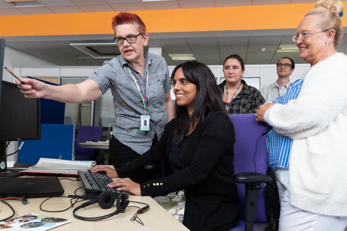 Group of people discussing a task on a screen