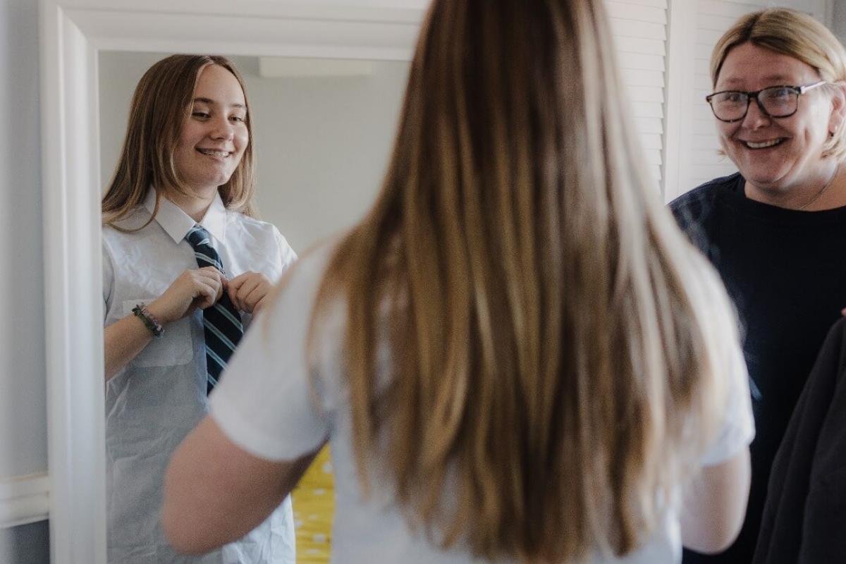 Foster carer and a young girl preparing for a school day