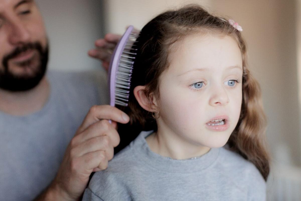 Foster carer brushing the hair of a young girl