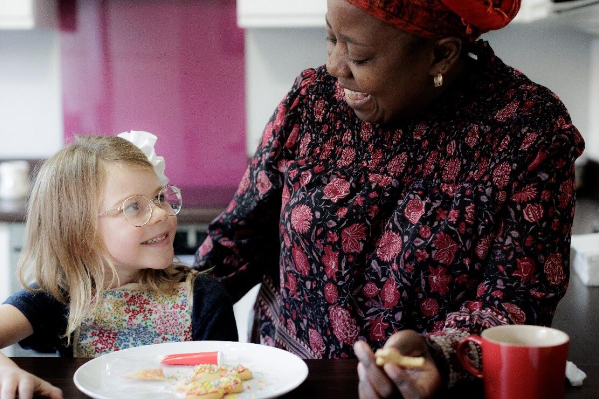 Foster carer and a young girl enjoying a meal