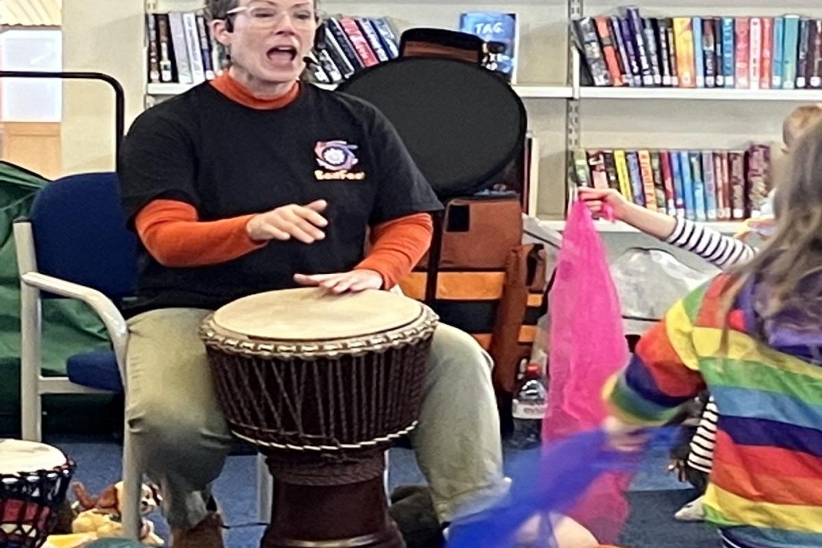 woman drumming and singing to chidren