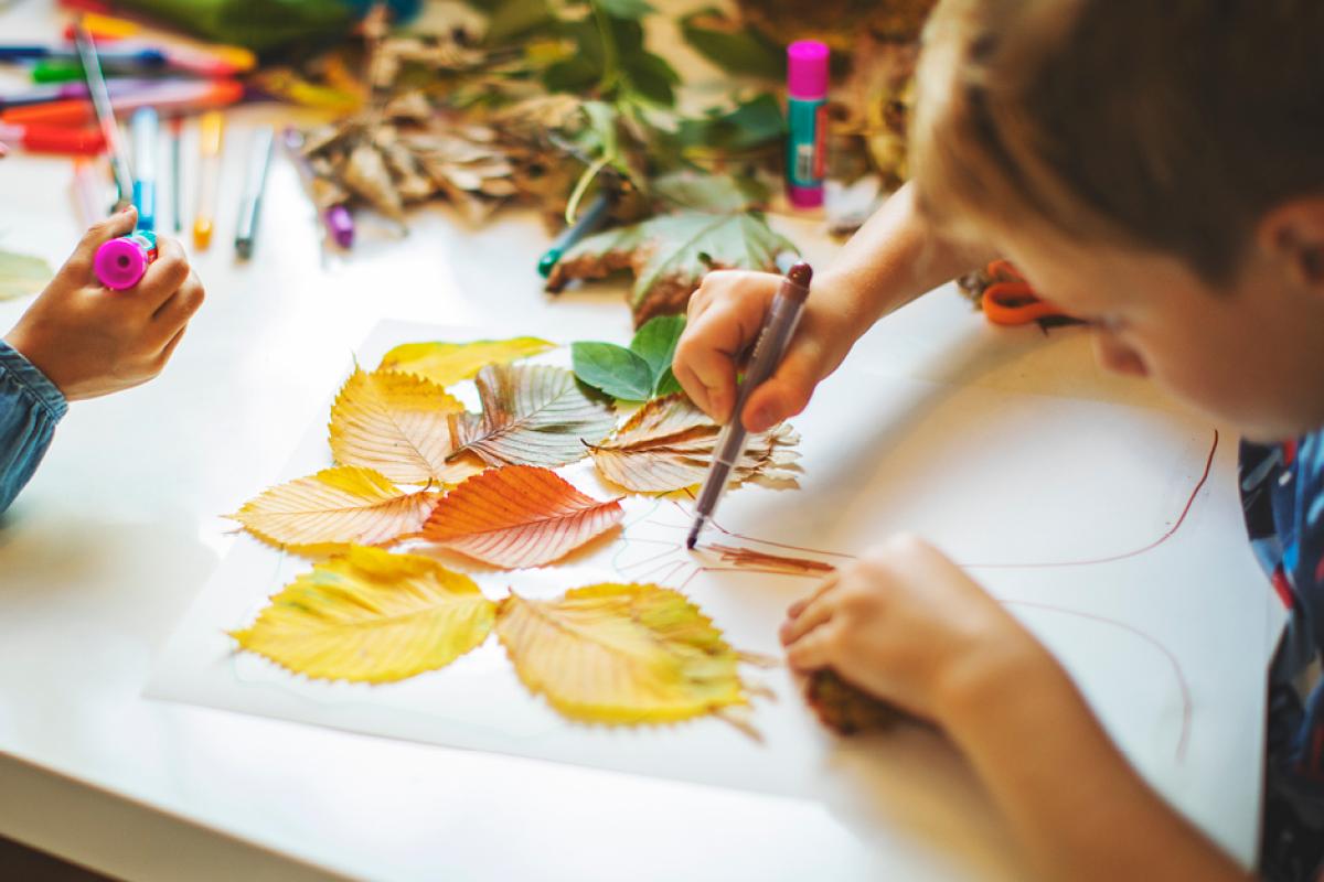 Child drawing autumn leaves