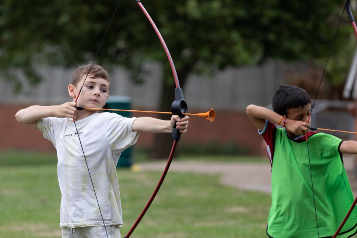 Child using a bow outside for archery