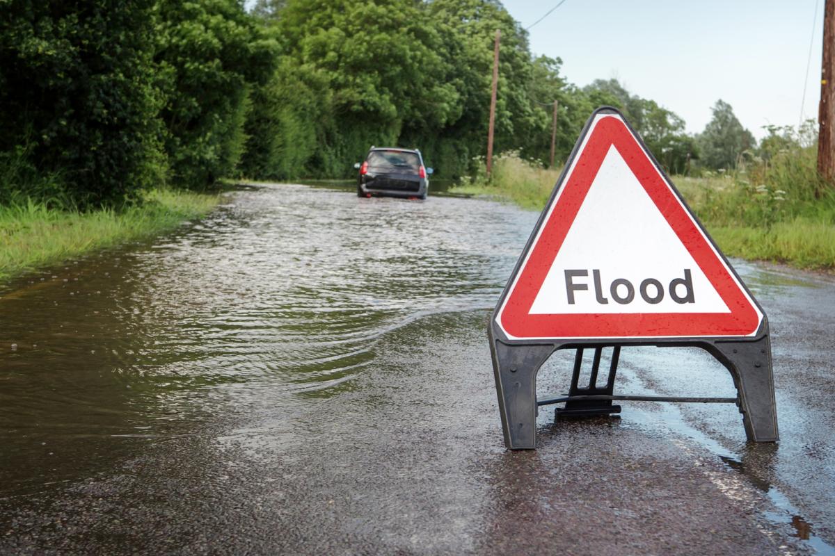 Flooded road with stranded car