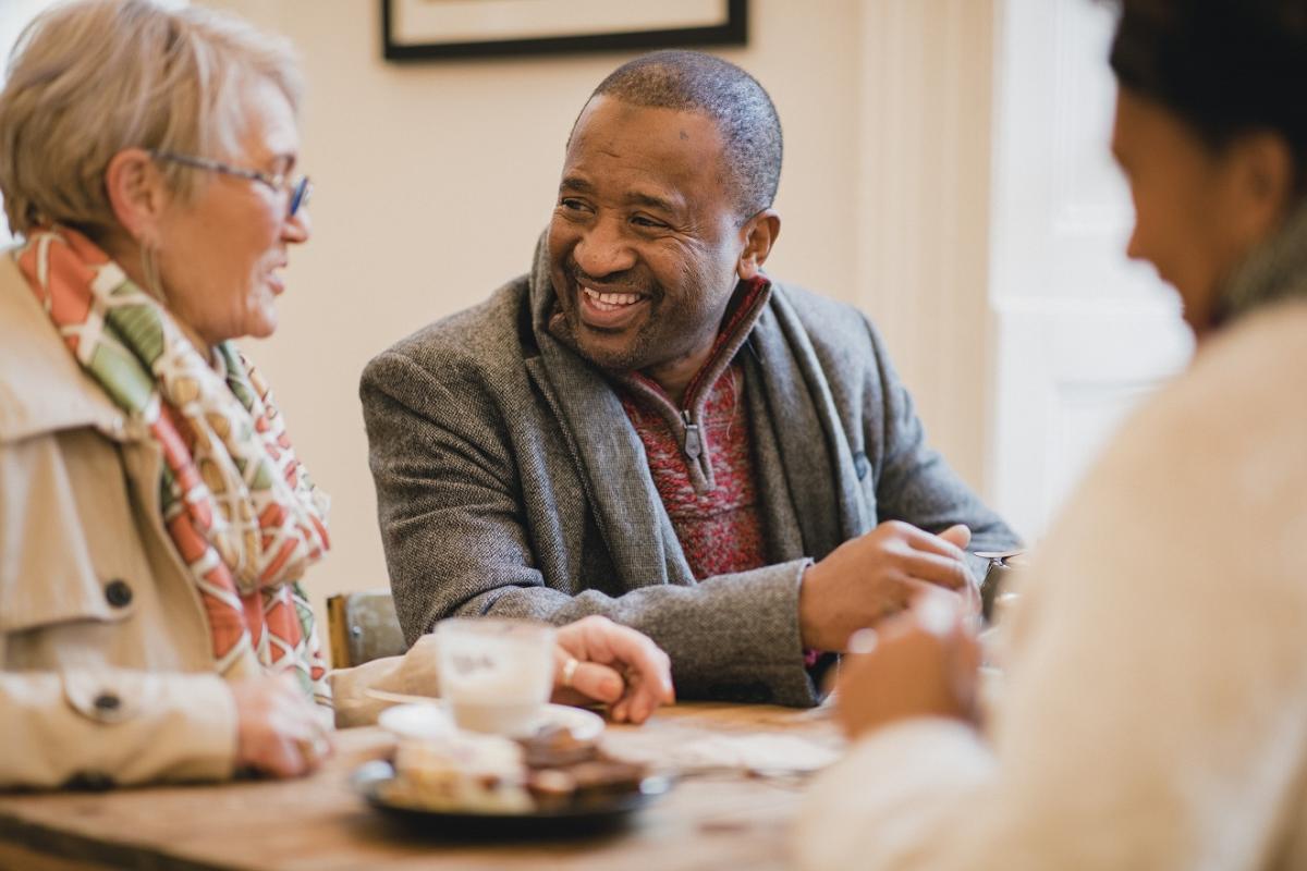 A group of people sitting at the table, chatting and smiling