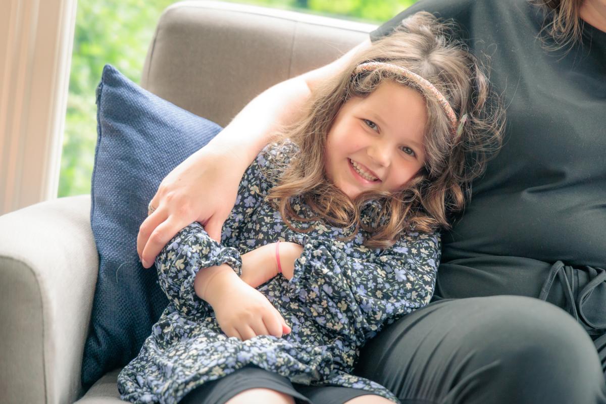 child sitting cuddled up next to parent