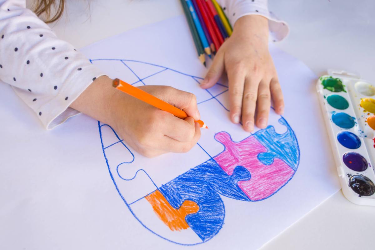 Child colouring in a picture of a colourful heart