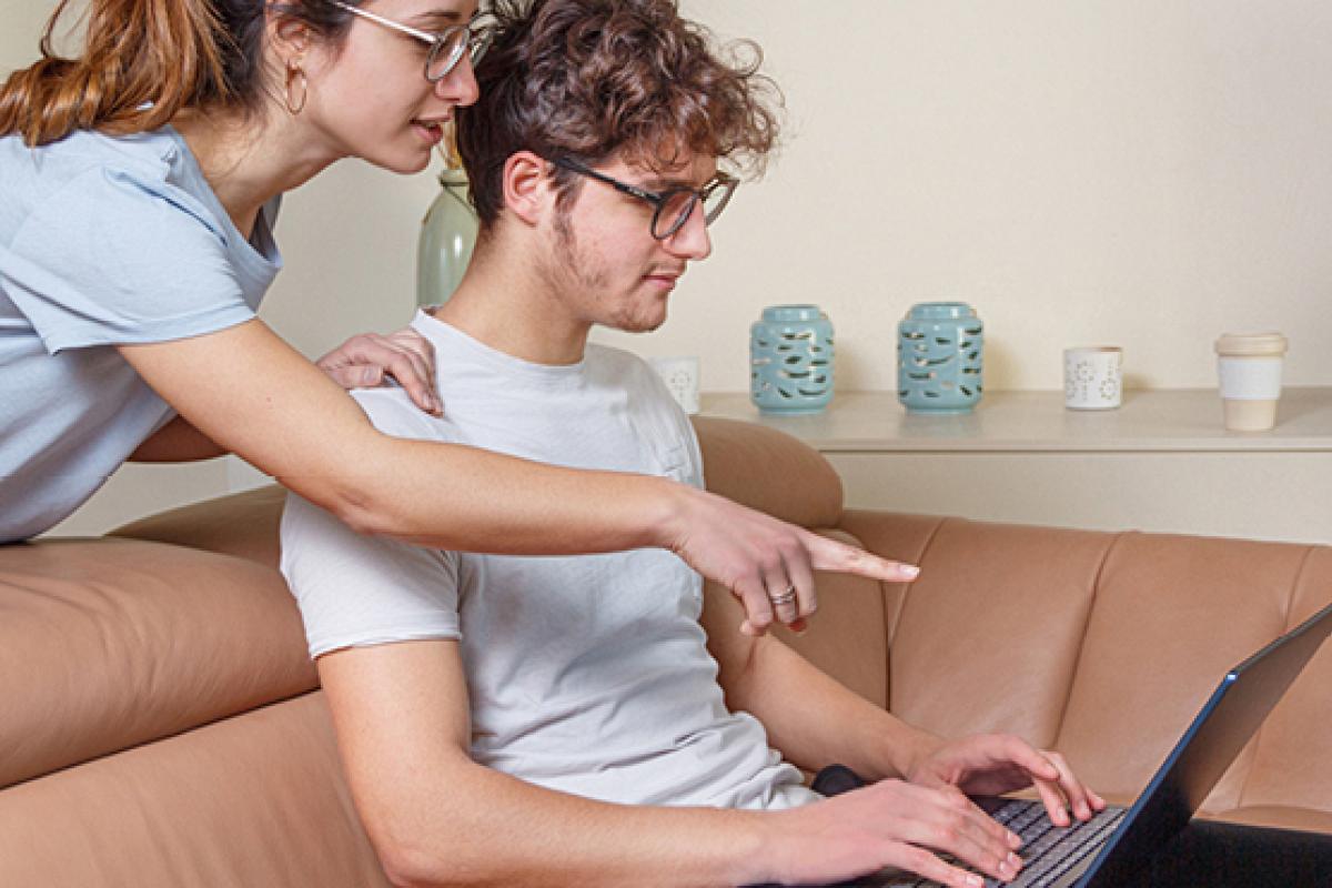 Two people looking at a laptop screen