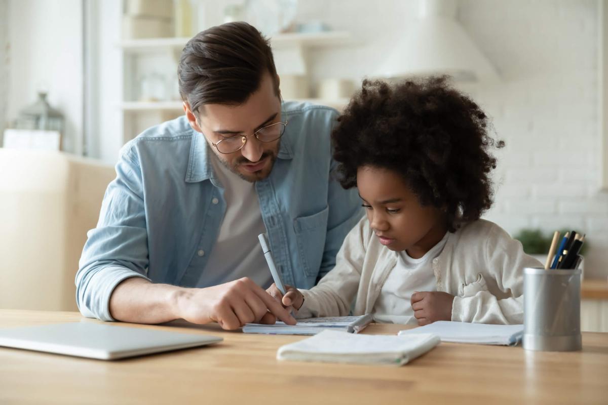 Dad helping daughter with school work at home