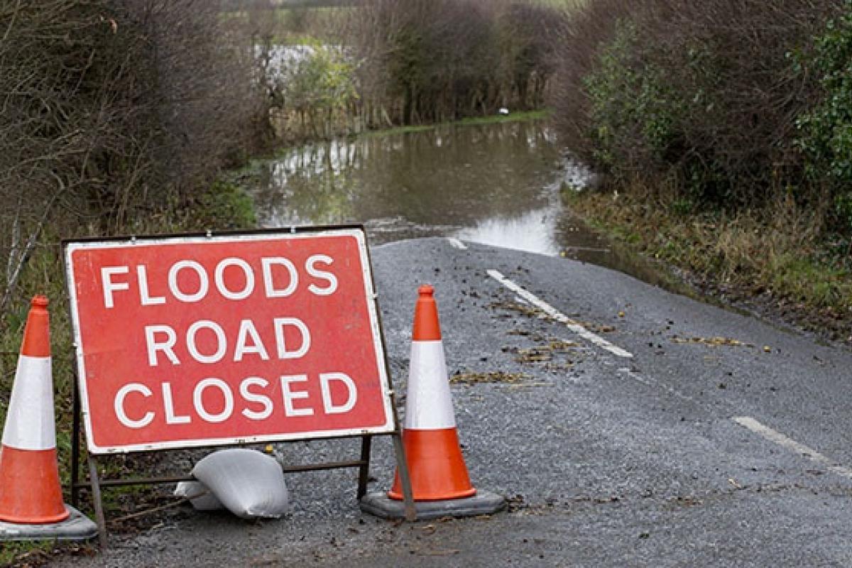 Flooded road with warning sign