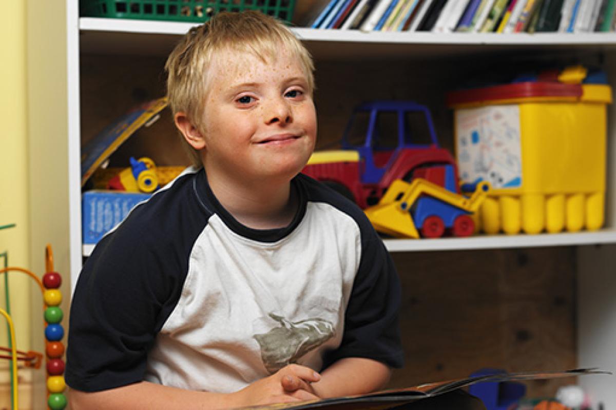 Young boy in front of bookcase at school