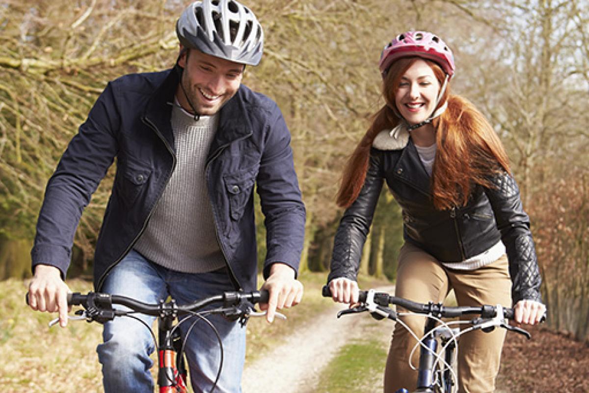 Two people riding bicycles on a woodland trail