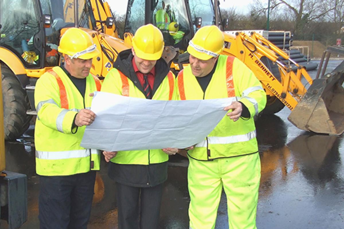 Road workers reading a map