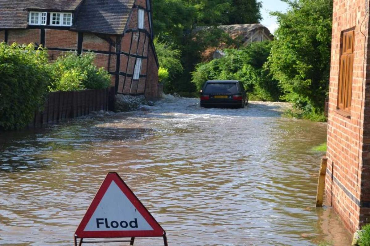 Flooded village with flood warning sign