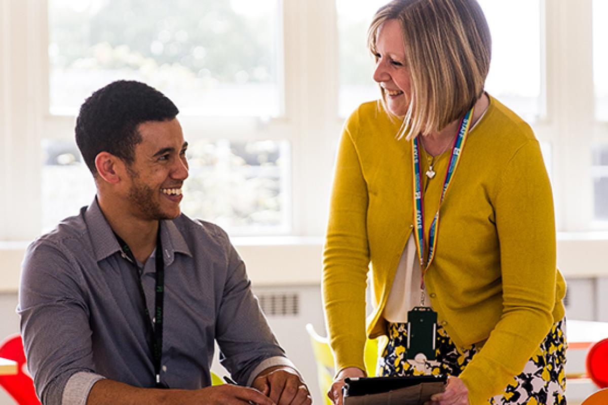 Two colleagues talking at a desk