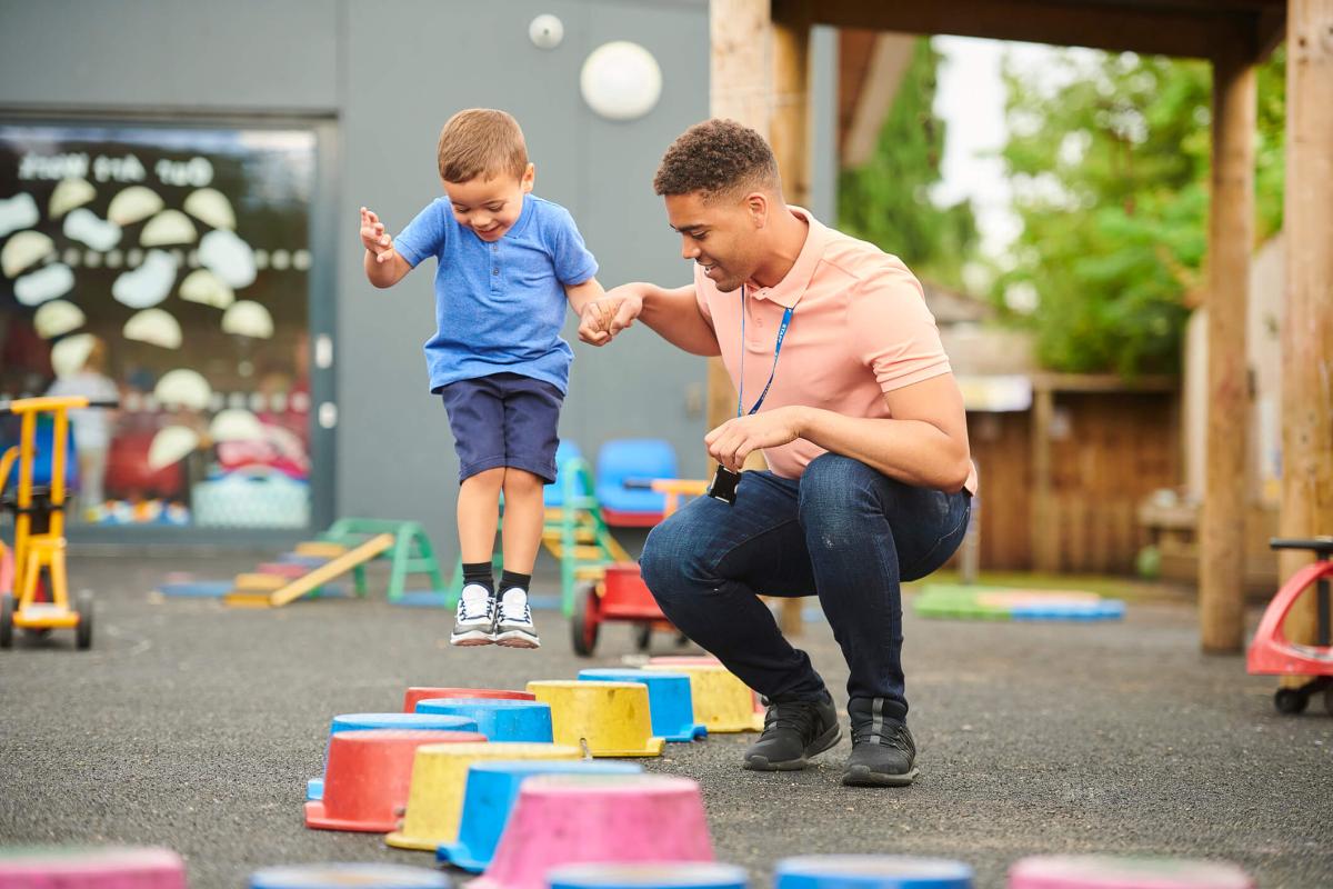 Teacher supporting a child on an obstacle course