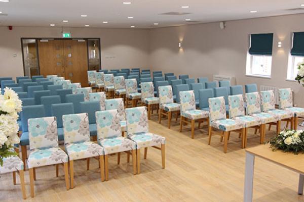 Room set up for a ceremony with the chairs arranged in a theatre style